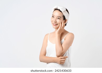 Image of young Asian woman wearing loungewear and turban doing beauty and skin care 库存照片