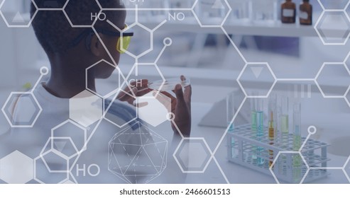 Image of elemental diagrams over african american schoolboy holding petri dish in science class. Science, chemistry, biology, school, childhood, education and learning, digitally generated image. 库存照片