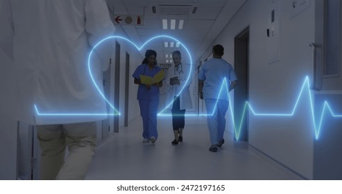Image of heart rate monitor over diverse female doctor and healthworker discussing at hospital. Medical healthcare and research science technology concept Stockfoto