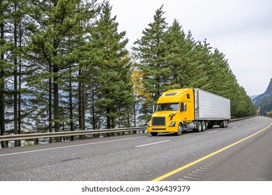 Industrial carrier long hauler classic yellow big rig semi truck tractor with high cab for truck driver rest transporting cargo in refrigerator semi trailer driving on the multiline highway road – Ảnh có sẵn