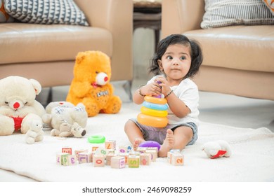 Indian baby sitting on floor playing with his toys
 Foto stock