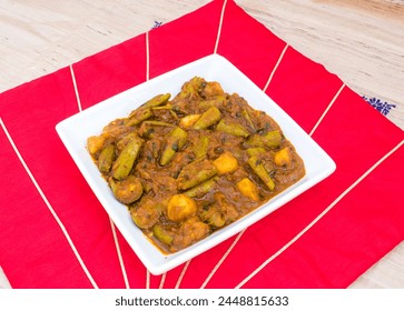 Indian Pointed Gourd Curry . Aloo Parwal Sabzi in white plate with red background Foto stock