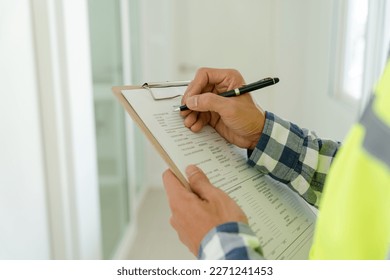 inspector or engineer is inspecting construction and quality assurance new house using a checklist. Engineers or architects or contactor work to build the house before handing it over to the homeowner: stockfoto