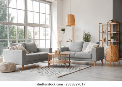 グレイのソファ、コーヒーテーブルと大きな窓と明るいリビングルームのインテリアの写真素材