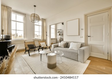 快適なソファと現代的な家で明るい窓の隣にある椅子を備えた広々とした豪華なリビングルームのインテリアの写真素材