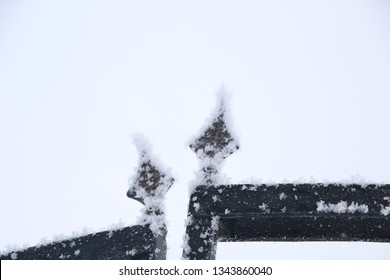 iron gate and fence with wrought iron elements covered with snow after a snowfall.の写真素材