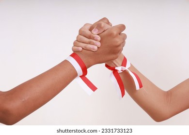 Kid's hands with red white ribbon holding each other. Indonesia independence day concept – Ảnh có sẵn
