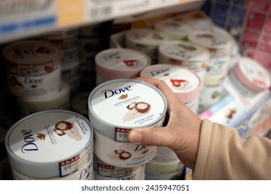 Kitakyushu, Fukuoka, Japan - March 9, 2024: A hand getting a container of Dove exfoliating cream at a supermarket.  ஸ்டாக் ஃபோட்டோ
