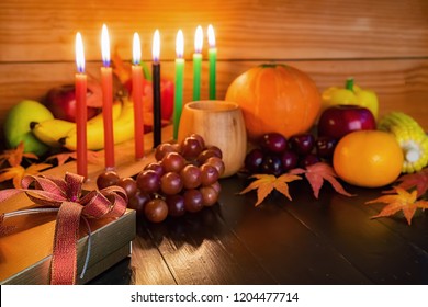 Kwanzaa holiday concept with decorate seven candles red, black and green, gift box, pumpkin,corn and fruit on wooden desk and background.: stockfoto