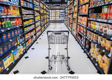 Редакционная стоковая фотография: KUALA LUMPUR, MALAYSIA - DECEMBER 26, 2023: Shopping cart trolley with a product on shelves at aisle of grocery store supermarket. Buying product item with variety of choice.
