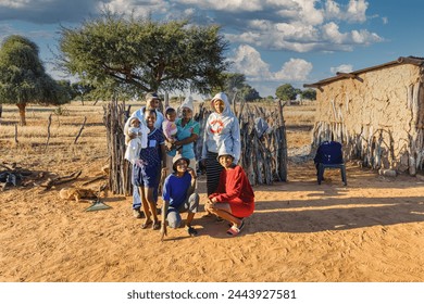 large african family in the village in front of the outdoors kitchen, mud house in the background, ngo charity helping ภาพถ่ายสต็อก