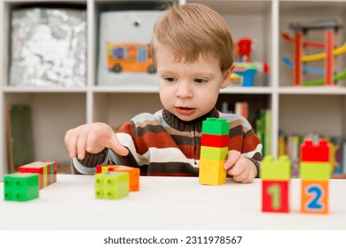Aprender a contar. Niño de 2 años apilando bloques Duplo. el concepto de infancia, infancia y educación. formación y desarrollo del niño. Montessori y desarrollo temprano Foto de stock