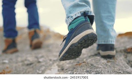 The legs of tourists go through the mountains on a journey. adventure mountains trekking concept. a group of tourists legs walk along top of the mountain rocks lifestyle close-up shoes स्टॉक फ़ोटो