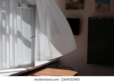 明るい白いカーテンが部屋の中で揺れる。天気の良い日に部屋に隙間風が入る。接写。の写真素材