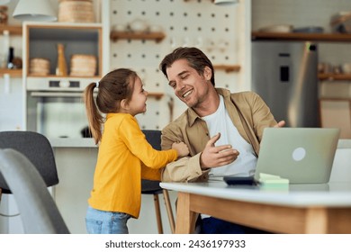 小さな女の子は、彼が自宅で、オンラインで作業している間、彼女のお父さんが彼女と一緒に遊ぶことを望んでいる。の写真素材