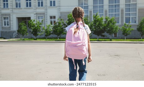 学校に行くバックパックを持つ小さな女の子、バックビュー。新学期の写真素材
