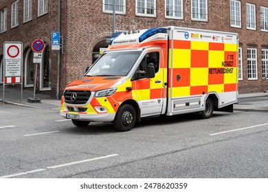 ドイツ、ルベック、2024年6月7日：緊急医師救急車は、旧市街を通って運転し、事故や健康災害の際に支援するために、コピーのスペース、選択されたフォーカスのエディトリアル写真素材