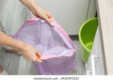 男性はバケツのゴミ袋を交換します。女性はゴミ袋を交換します。空のゴミ袋。空のゴミ箱。高品質の写真の写真素材