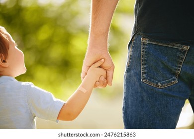 Man, child and holding hands back outdoor park together for bonding, love and support on summer vacation. Father, son and walking with care, trust and morning travel for holiday freedom of memory Stock fotografie