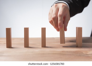 Man hand pick one of many wood block from many wood block in row, risk business concept in choose challenge  idea strategy  different management 
 庫存照片