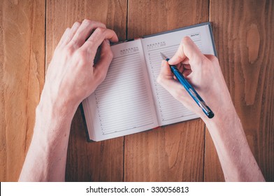Man hands writing notes in daily planner 庫存照片