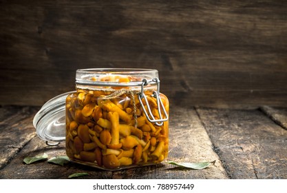 Marinated mushrooms of honey agarics in glass jar. On a wooden background., fotografie de stoc
