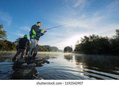 Des hommes pêchant dans la rivière avec des bâtonnets à mouches pendant la matinée d'été. Beau brouillard. : photo de stock