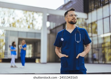 Medical professional working in a hospital. He is dressed in scrubs looking at the camera smiling with a stethoscope around his neck. Young male nurse home caregiver  Stockfoto
