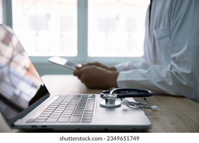 Medicine doctor working with computer notebook in the hospital. Physician input patient data and order some medicine online. 库存照片