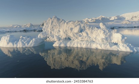 Melting ice - Global Warming. Iceberg Reflection in Slow Motion. Go Down View of Huge Ice Floe Melt in Clear Ocean Winter Water. Climate Concept. South Pole Majestic Panorama Drone Flight. Foto Stock