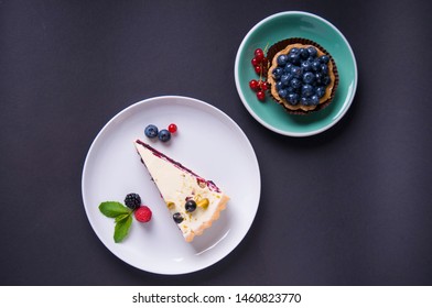 meringue pie and whole-grain sand tartlet with blueberries, on a black background. Top view 库存照片