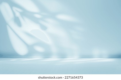 Minimalistic abstract gentle light blue background for product presentation with light and intricate shadow from tree branches on wall.: stockfoto