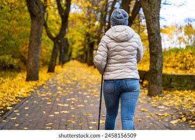 Mid-adult woman exercising Nordic walking in city park – Ảnh có sẵn