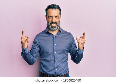 Стоковая фотография: Middle age man with beard and grey hair wearing business clothes shouting with crazy expression doing rock symbol with hands up. music star. heavy concept. 