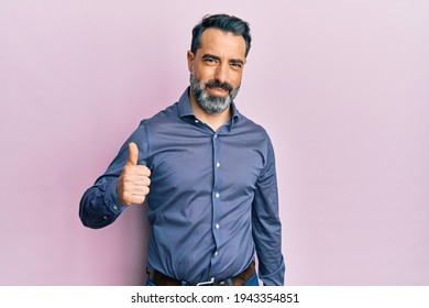 Стоковая фотография: Middle age man with beard and grey hair wearing business clothes doing happy thumbs up gesture with hand. approving expression looking at the camera showing success. 