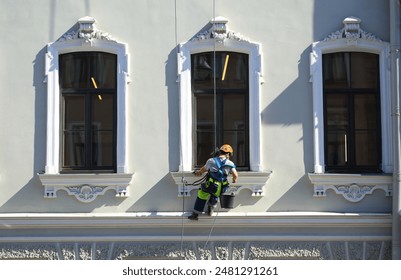 Millionnaya Street, St. Petersburg, Russia, June 26, 2024: An industrial climber washes the windows of an old building, fotografie de stoc Editorial