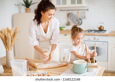 Mom and daughter are cooking in the kitchen of a country houseの写真素材