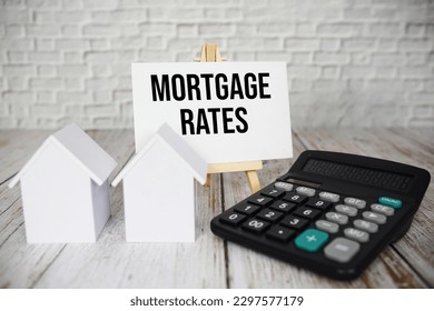 Mortgage Rates text message with calculator and house model on wooden background स्टॉक फोटो