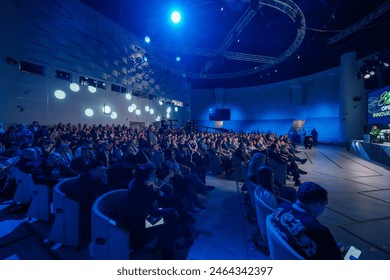 Moscow - April 10, 2024: Large audience attentively listens to a keynote speaker on stage during a professional conference Open Innovations in Skolkovo Innovation Center 编辑库存照片