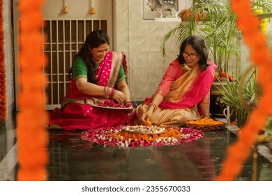 Mother-in-law and daughter-in-law decorating house with lamps and flowers on the occasion of Diwali Stock Photo