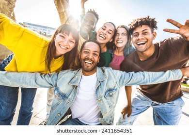 Multiracial group of young people smiling at camera outside - Happy friends having fun walking on city street - Youth community concept with different guys and girls hanging out on summer day time Foto stock