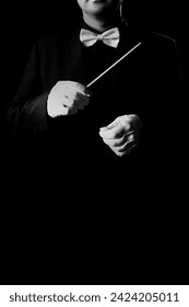 Music conductor orchestra conducting isolated on black background. Hands with baton in white gloves and bowtie  Stockfoto