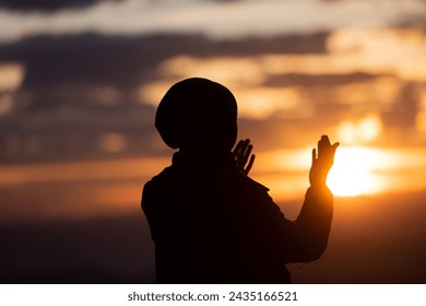 Muslim woman prayer praying with hands up open doing dua at sunset worship Allah.: stockfoto