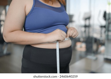 다이어트 개념에서 뚱뚱한 배를 가진 비만 여성. 뚱뚱한 배를 만지고 체중을 감량하고자하는 과체중 여성 센티미터로 뚱뚱한 여성 허리 건강한 위 근육을 모양  스톡 사진