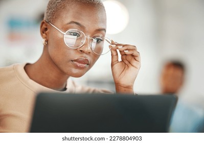 Office, computer and black woman with glasses, serious or reading email, online research or report. Laptop, concentration and African journalist proofreading article for digital news website or blog 库存照片