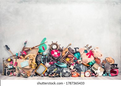 Old antiques and retro collectibles memorabilia dumped in a huge pile. Garage sale, attic room storage conceptual still life or disposal and recycling of outdated objects. Vintage style filtered photo Stock Photo