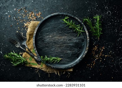 Old wooden black plate. Top view. On a stone dark background. Stock Photo