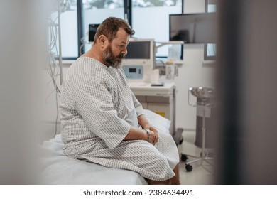 Overweight patient in hospital gown waiting for medical examination, test results in hospital, feeling anxious. Patient feeling dizzy, have vertigo and intense pain. स्टॉक फ़ोटो