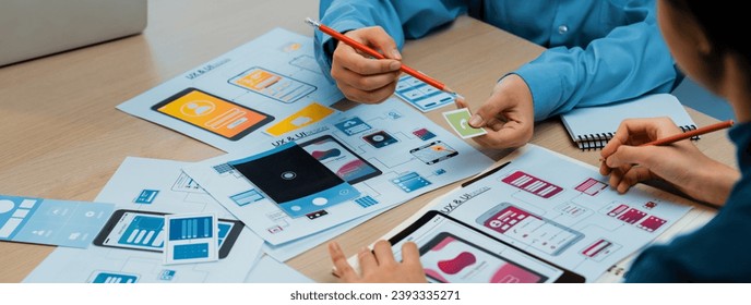Стоковая фотография: Panorama banner of startup company employee planning on user interface prototype for mobile application or website in office. UX UI designer brainstorm user friendly interface plan. Synergic
