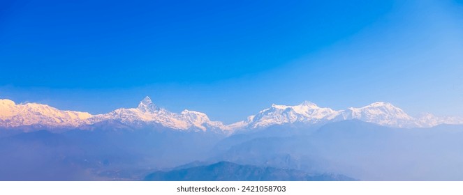 Panoramic view of the Himalayas from Sarangkot hill near Pokhara in Nepal.Colorful landscape of Nepal with winter blue sky.Snowcap mountain with space in panorama.Bright blue sky with snow in Nepal. Foto stock